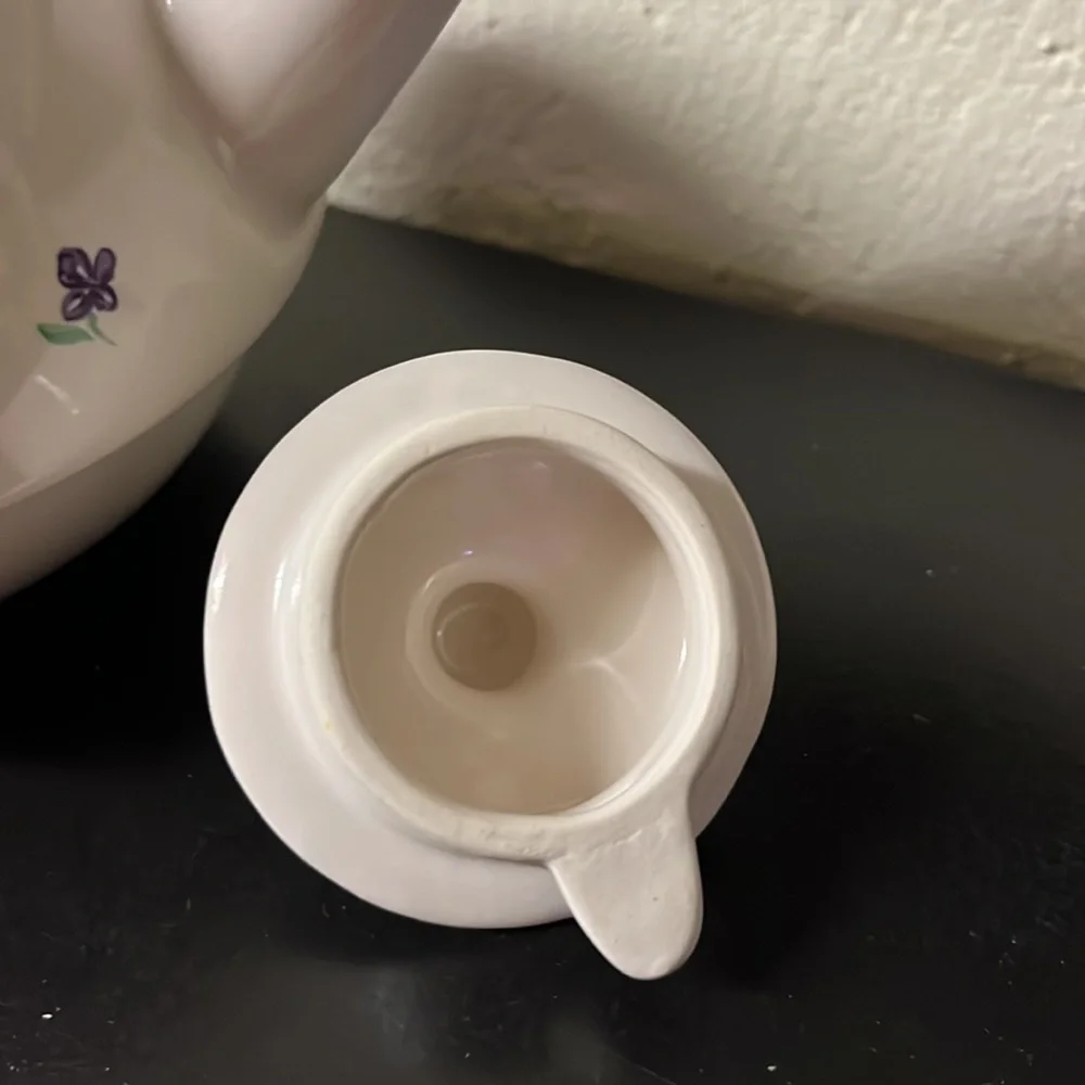 Small white teapot with violet and bee details.